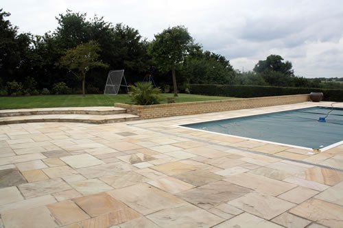 New stone terrace and extended garden wall around a pool